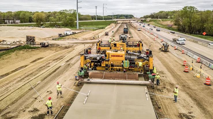 Concrete paving train laying a highway slab